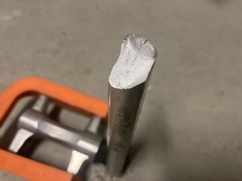 Broken bicycle pedal. Cracked orange plastic part in background. Close up of crack