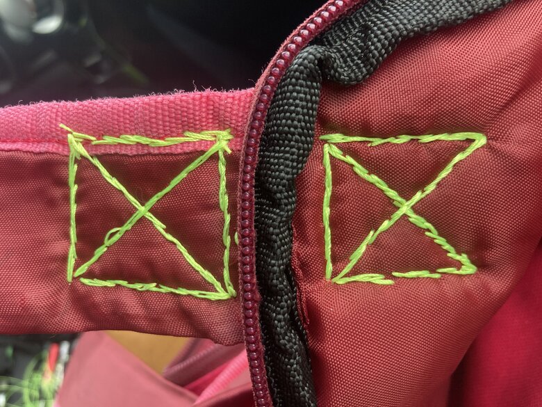 View of the strap and inside of the backpack showing the back of the figure eight patterns